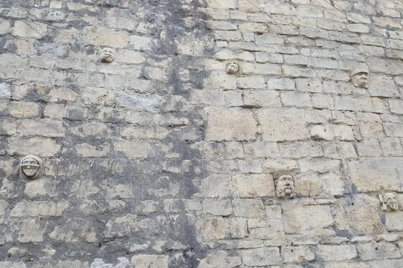 The grotesque stone faces on the wall of The Paragon in Walcot Village