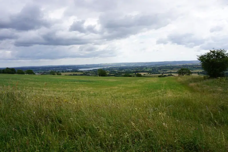 Views of verdant field in the foreground, and the Chew Valley, the Chew Valley lake and the Mendip Hills in the background