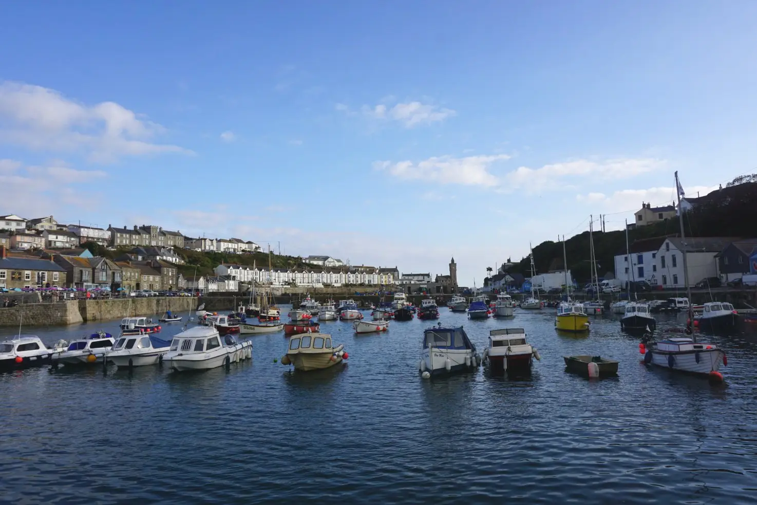 Harbour of Porthleven in Cornwall with moored boats and lined terraced houses