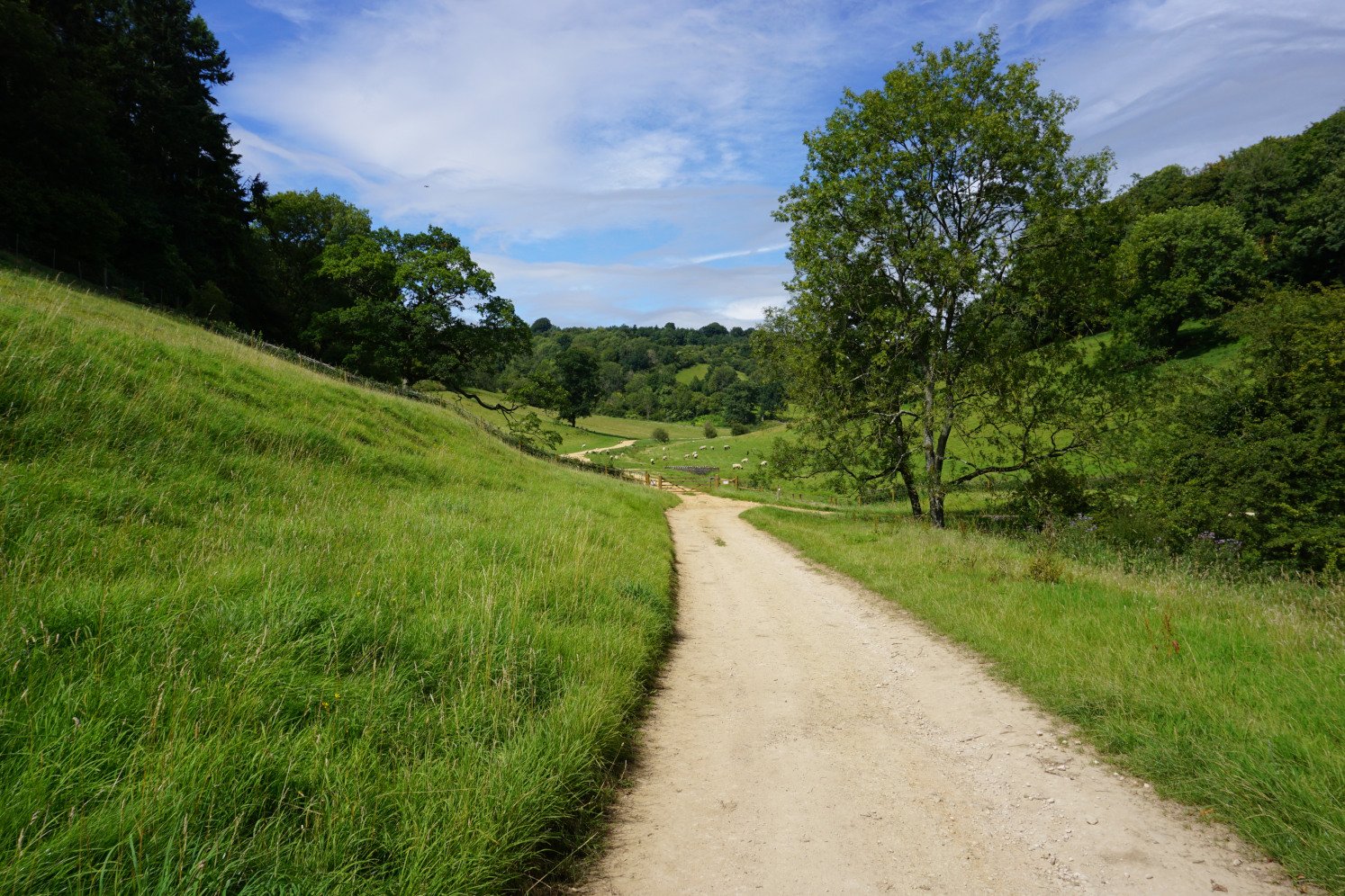 Walking along a pebbled path from the quaint Ozleworth Park to the hidden Bagpath valley in the Ozleworth and Lasborough valley walk