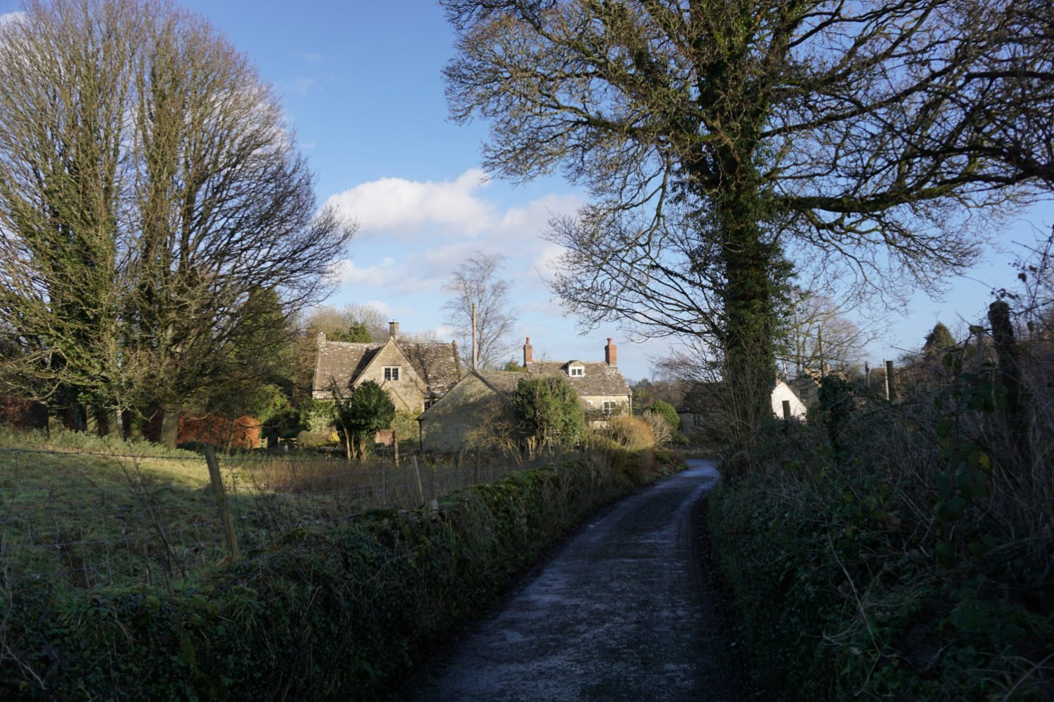 Country lane and charming cottages in the Cotswold village of Nympsfield