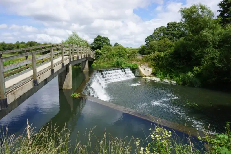 Cowbridge Weir, a wooden bridge and the River Avon near Malmesbury