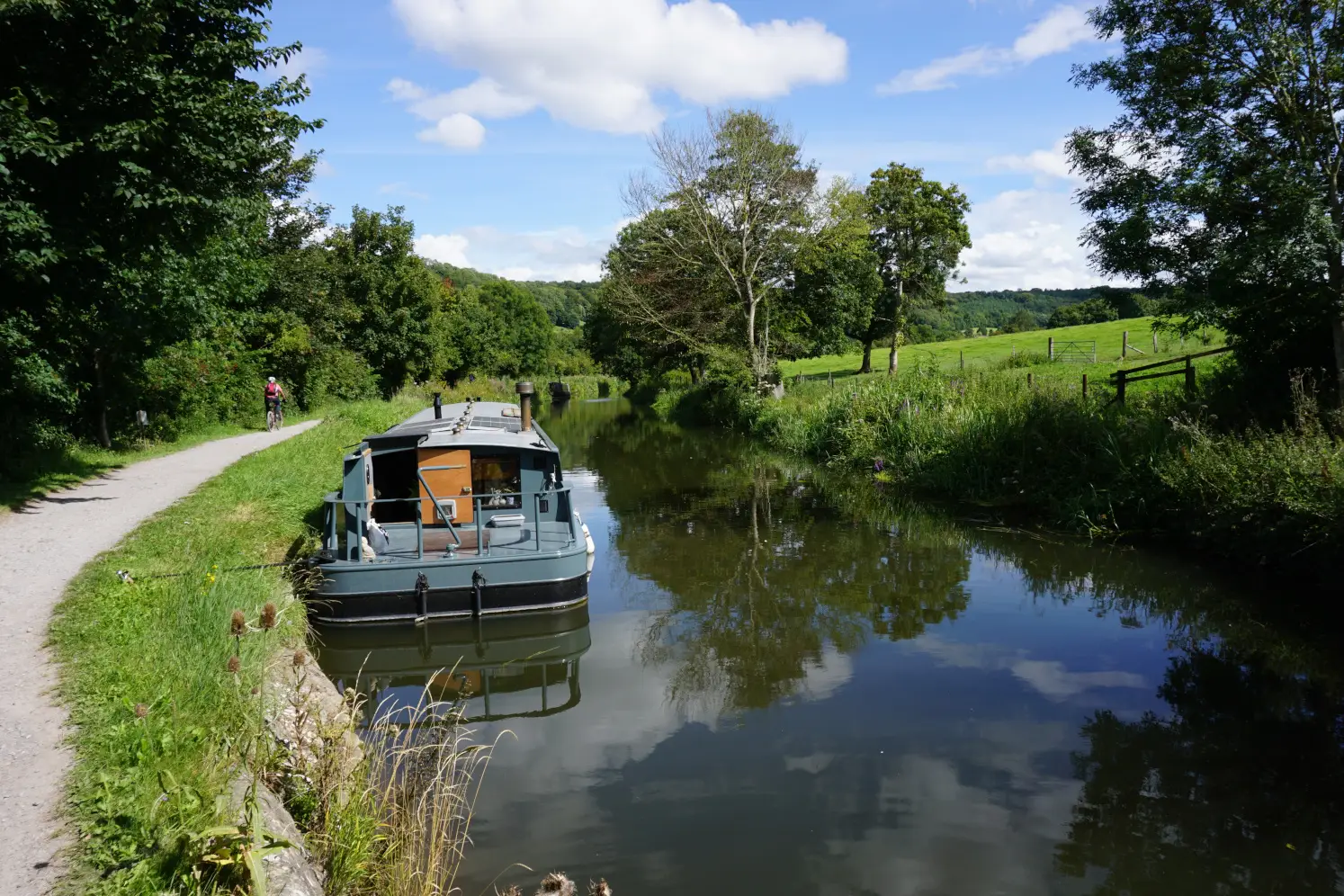 A canal boat, a canal path and the Kennet & Avon canal between Bath and Bradford-on-Avon