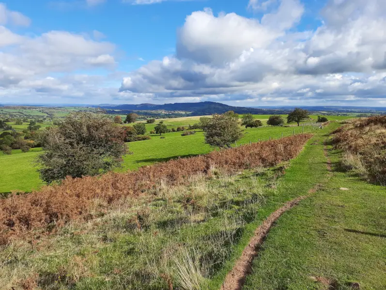 Walking across open moorland at the base of the Skirrid Mountain